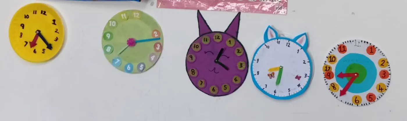 Row of Grade 2 clock crafts including cat and paper plate designs
